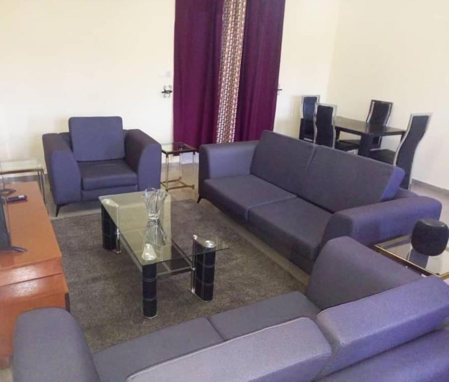 雅温得Comfort Zone Apartment的客厅配有紫色沙发和桌子