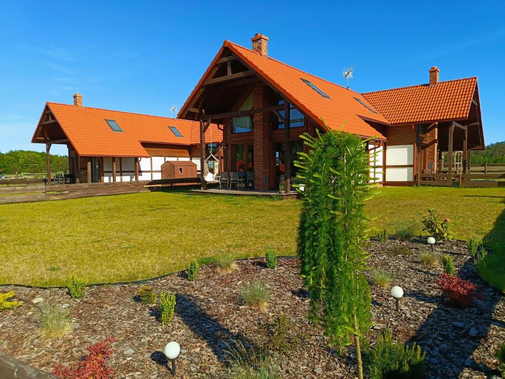Borowy MłynRozmaryn - Komfortowy domek całoroczny na Kaszubach的一座带橙色屋顶的大房子