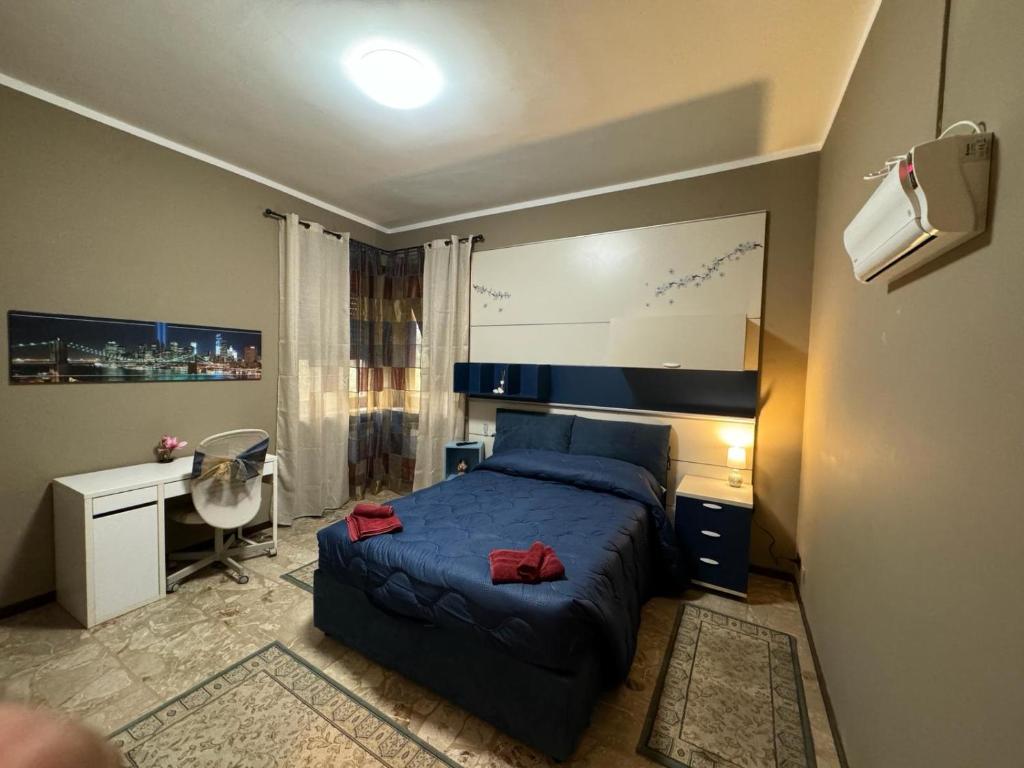 Piossascoking's house的一间配备有蓝色床和一张书桌的小卧室