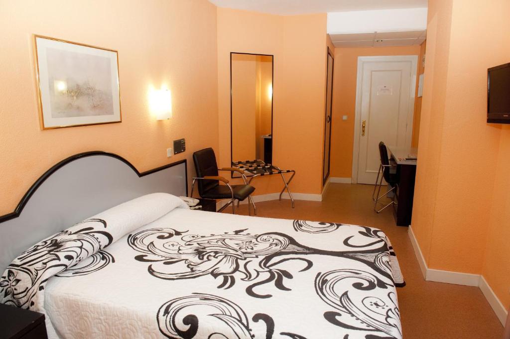 桑坦德Hotel Arha Santander的一间卧室配有一张带黑白毯子的床