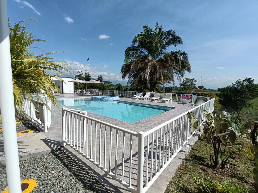 金巴亚Colina del Sol Hotel Hacienda的游泳池周围设有白色围栏