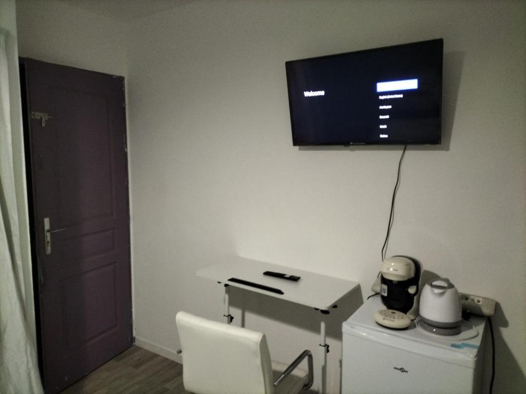 安东尼Chambre à 10 minutes de Paris的客房设有书桌和墙上的电视。