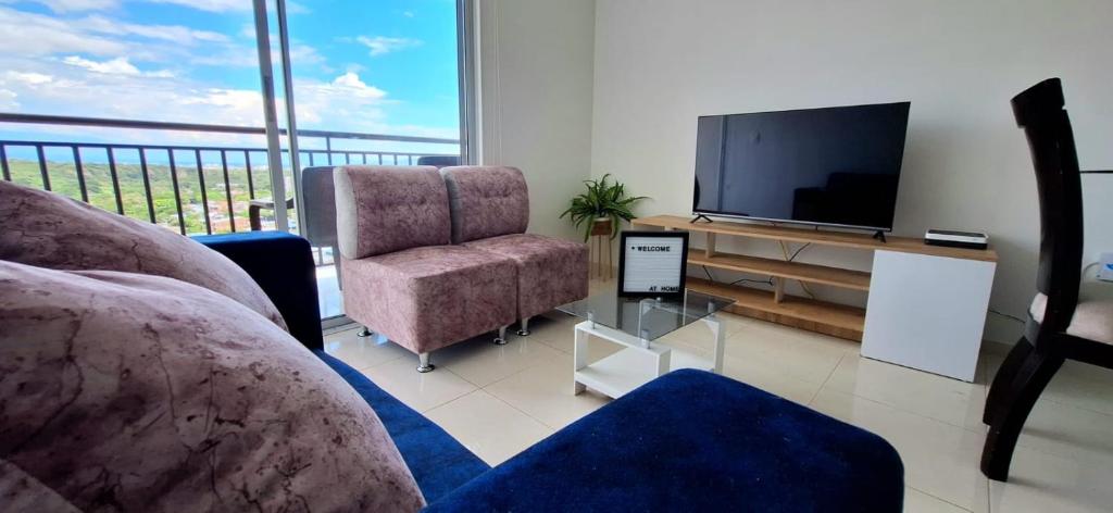 内瓦AG Somos AT HOME APTO con Aire Acondicionado con vista a toda la ciudad的客厅配有电视、沙发和椅子