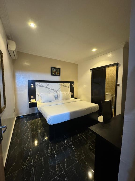 伊凯贾Posh Hotel and Suites Ikeja的卧室配有一张白色大床