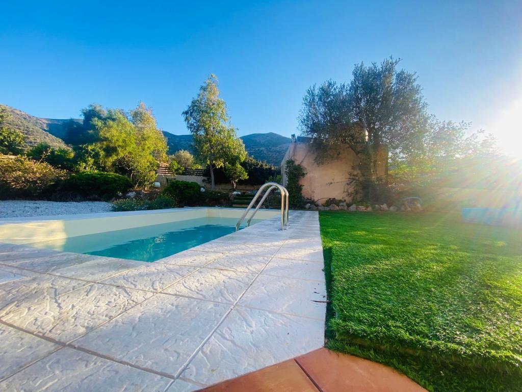 斯塔里斯Astali Villa的一座带绿色草坪的庭院内的游泳池