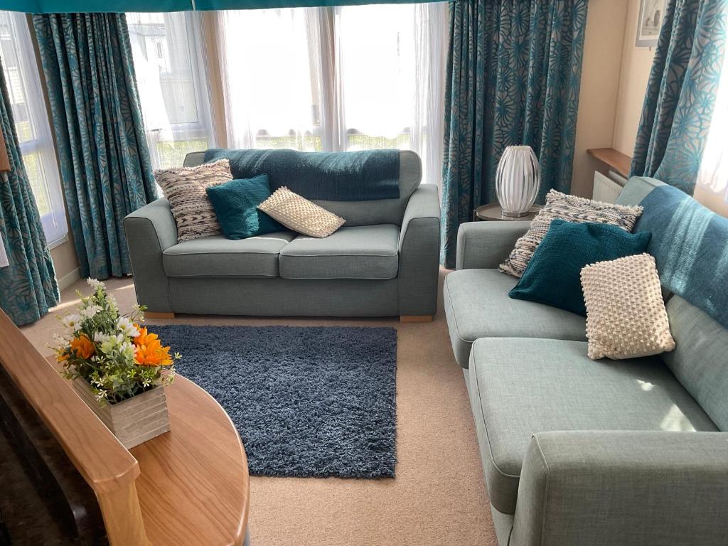 GreatstoneRomney Sands holiday home的客厅配有两张沙发和一张桌子
