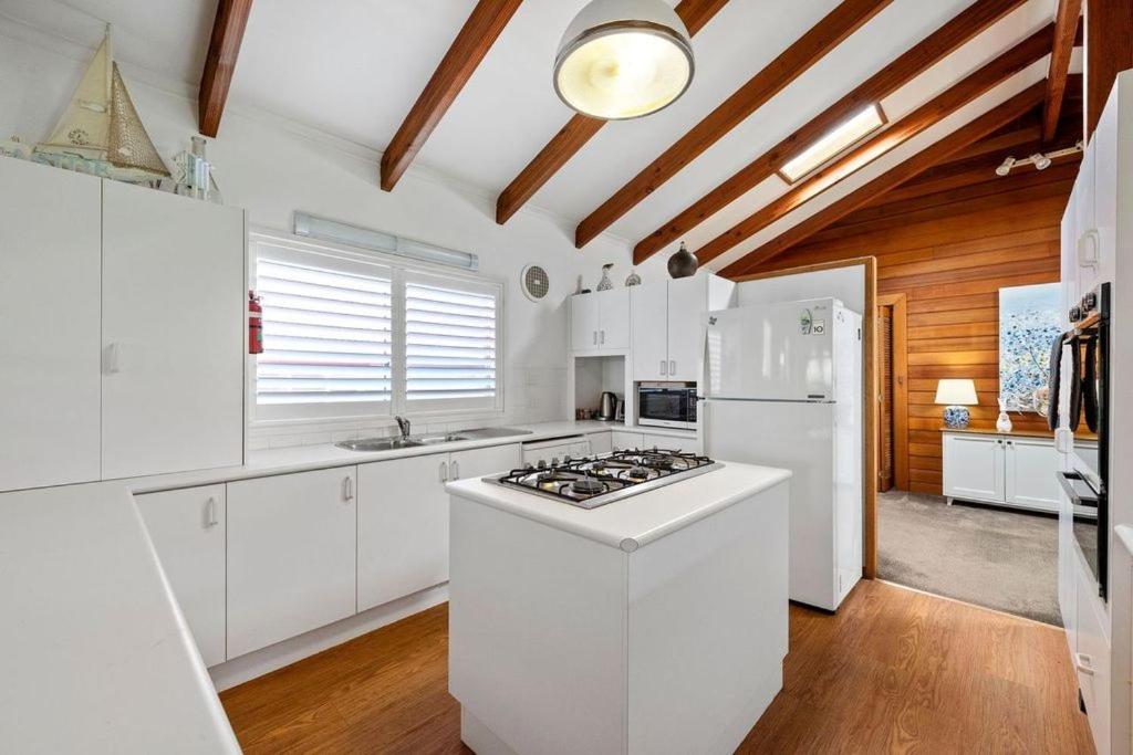 莫里莫科莫利穆克梦幻度假屋的厨房配有白色橱柜和炉灶烤箱。