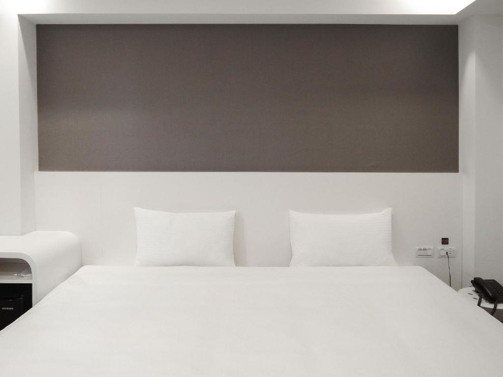 台北雀客快捷台北永康的卧室配有白色床和白色大床罩