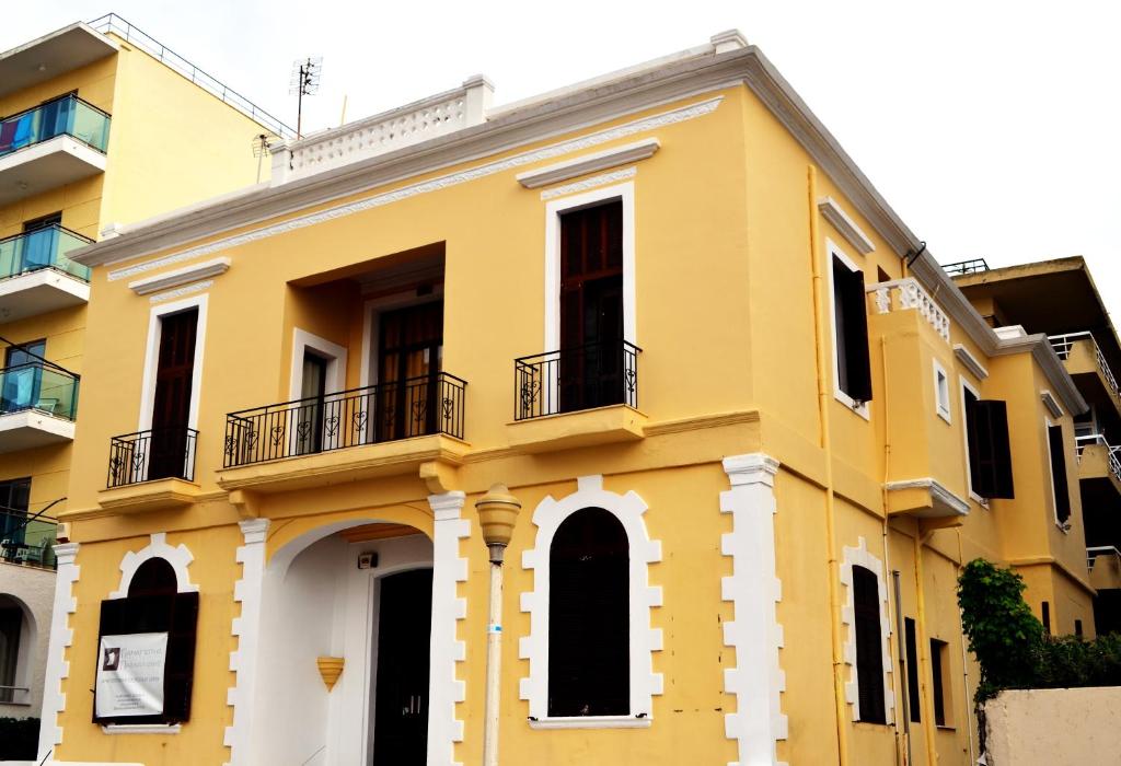 罗德镇City center beach house的黄色的建筑,设有两个阳台