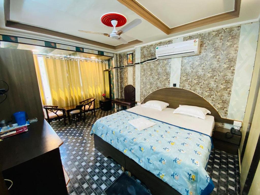 瓦拉纳西Hotel Regard的一间酒店客房,一间设有一张床和一张书桌