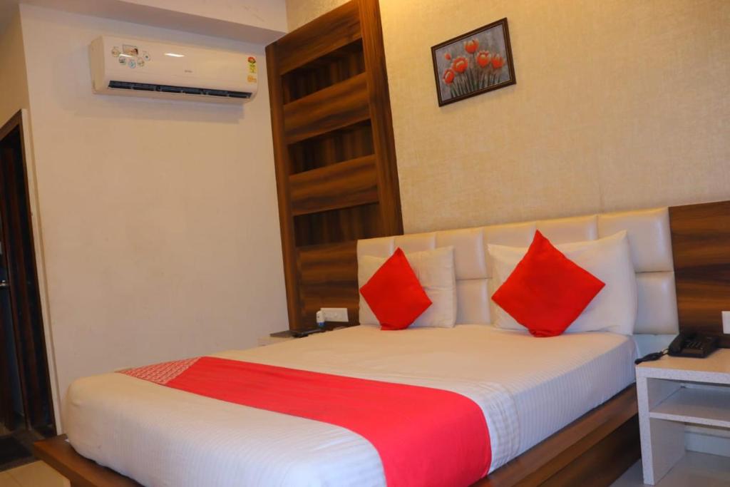 艾哈迈达巴德HOTEL LORDS IN的配有红色枕头的床的酒店客房