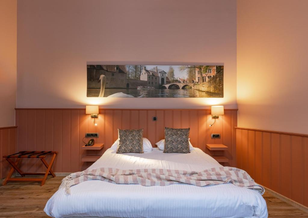 布鲁日马勒贝格酒店的卧室配有一张床,墙上挂有绘画作品