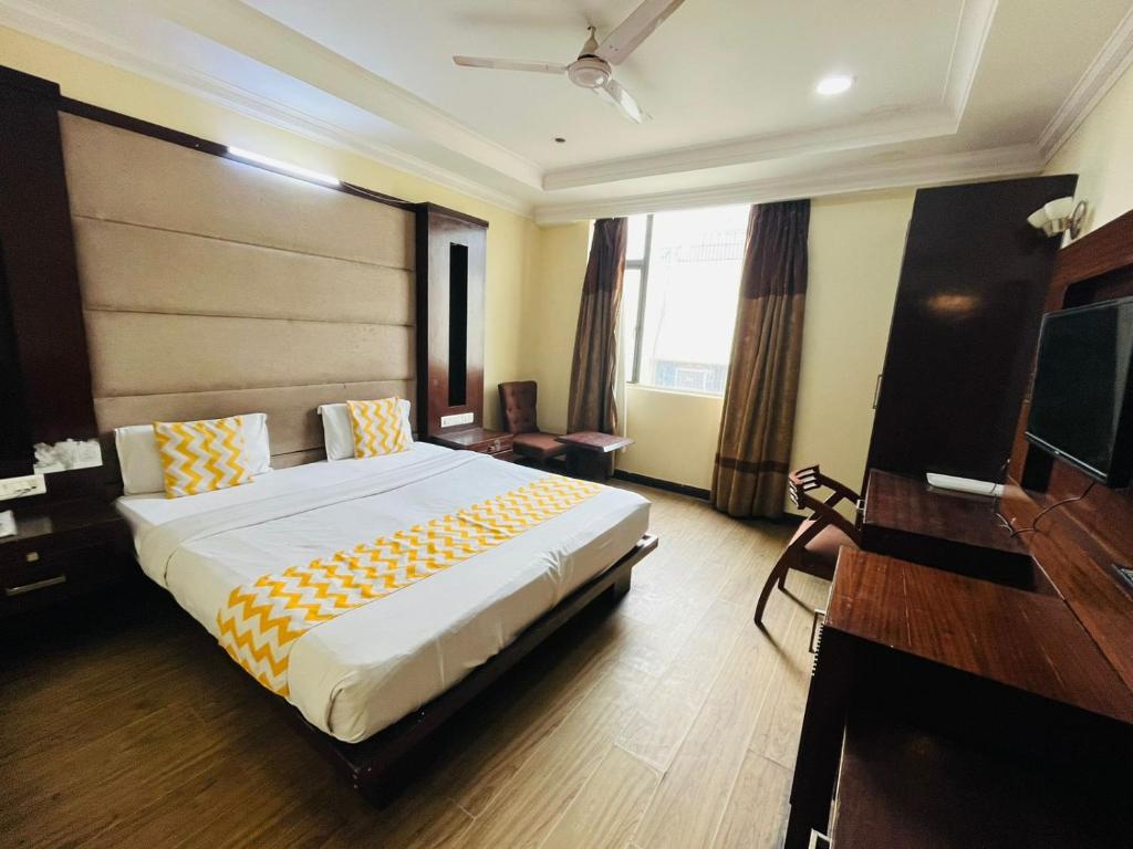 新德里Hotel Imperial Inn - Nehru Enclave的酒店客房设有一张大床和一张书桌。