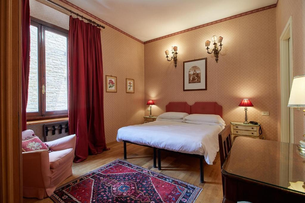 佛罗伦萨赫米缇吉酒店的卧室配有床、椅子和窗户。