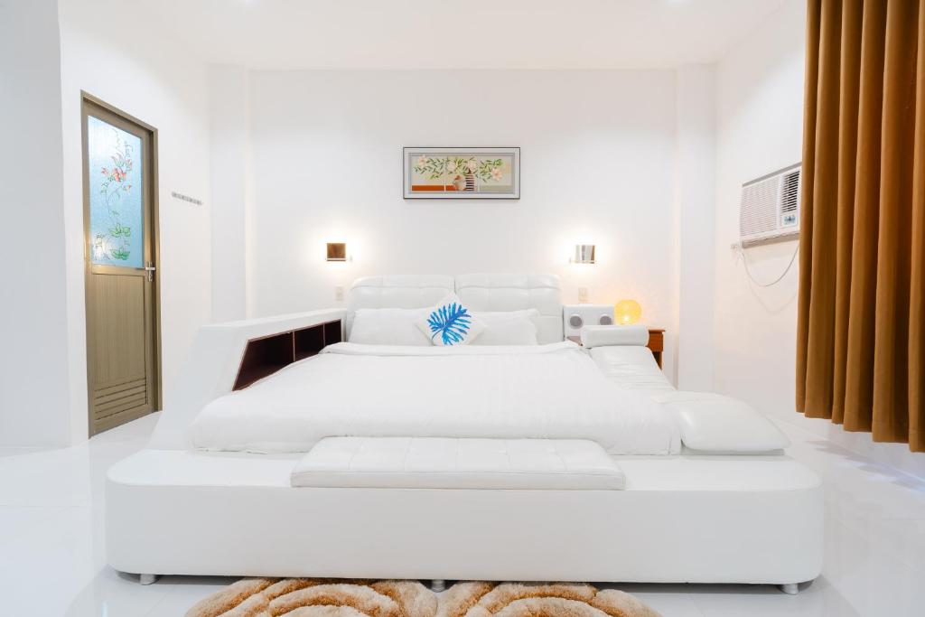 CabanganQ Beach Resort的一间白色卧室,内配两张白色的床