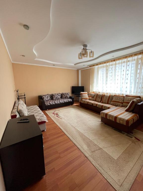 阿斯塔纳ЖК «Нурсая»的带沙发和电视的大型客厅