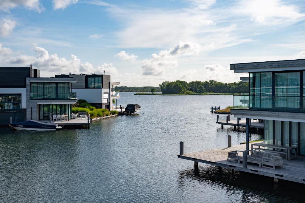 阿讷默伊登Dormio Harbour Village的享有河流美景,设有房屋和码头