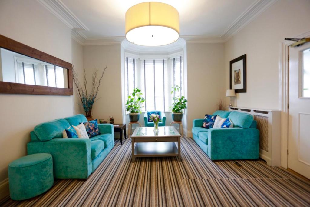 埃克斯茅斯埃克斯茅斯海豚酒店的客厅配有2张蓝色的沙发和1张桌子