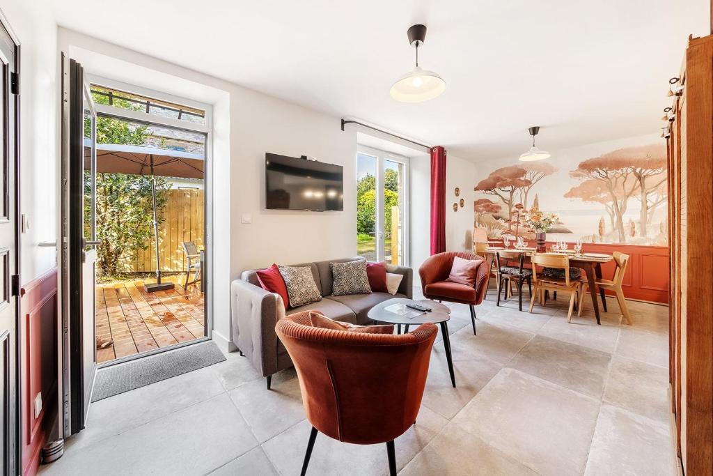 康卡勒LE ROCHER- Belle maison de charme -Jardin/Parking的客厅配有沙发和桌子