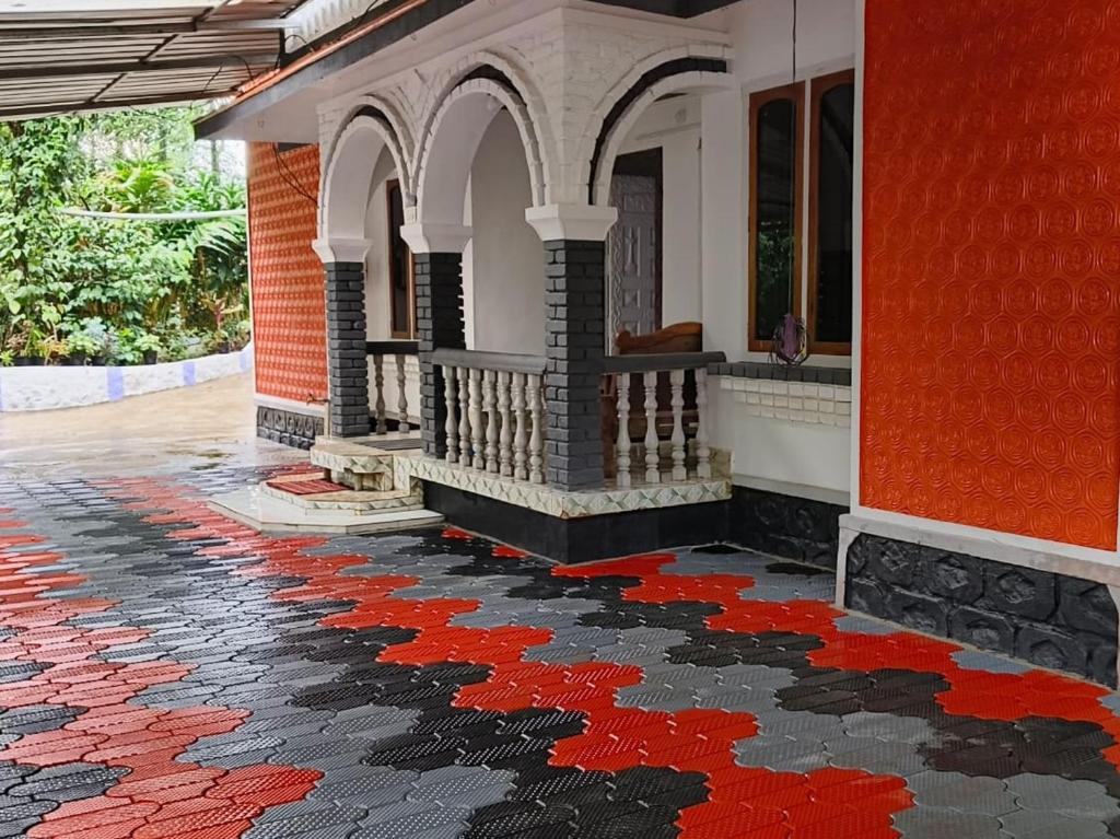 德维科拉姆Suryas Home Stay的铺有红色和黑色瓷砖地板的房子