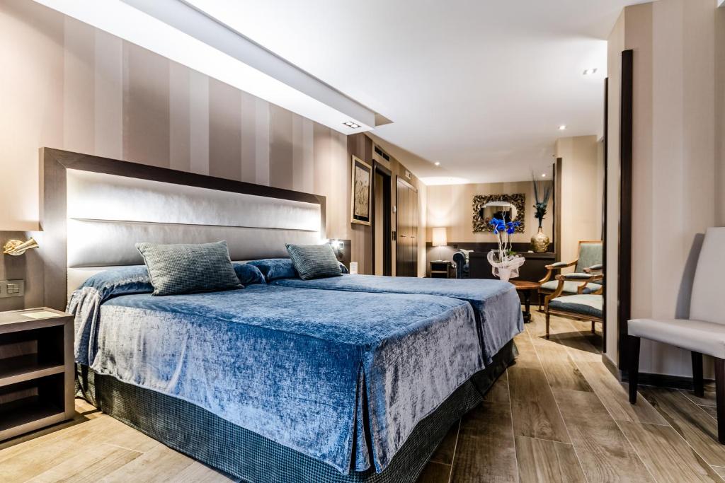 特鲁埃尔Hotel Reina Cristina的一间卧室配有一张大床和蓝色的床罩