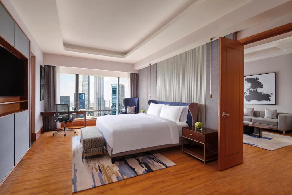 雅加达雅加达麦卡库宁冈丽思卡尔顿酒店的一间卧室配有一张床、一张桌子和一张沙发