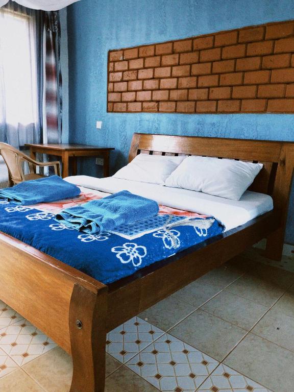VoiVineyard Retreat Voi的卧室内的一张床铺,卧室内有蓝色的墙壁