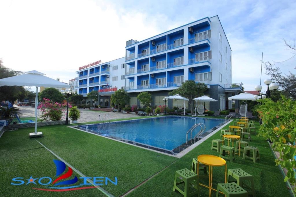 清化Sao Biển Hotel Hải Tiến的一座带游泳池和椅子的酒店和一座建筑