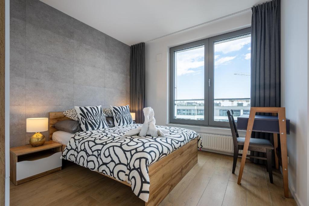格丁尼亚04 Gdynia Premium - Apartament Mieszkanie dla 2 osób z parkingiem的一间卧室设有一张床和一个大窗户