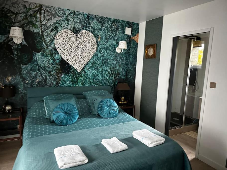 BignanMaison en pleine campagne的一间卧室配有绿床和2条毛巾