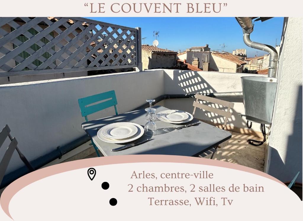 阿尔勒"Le couvent bleu" Arles arènes Terrasse的阳台上的桌子,上面有盘子和玻璃杯