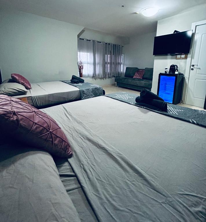 埃拉特Toys suites hotel的一间有两张床和一台电视的房间