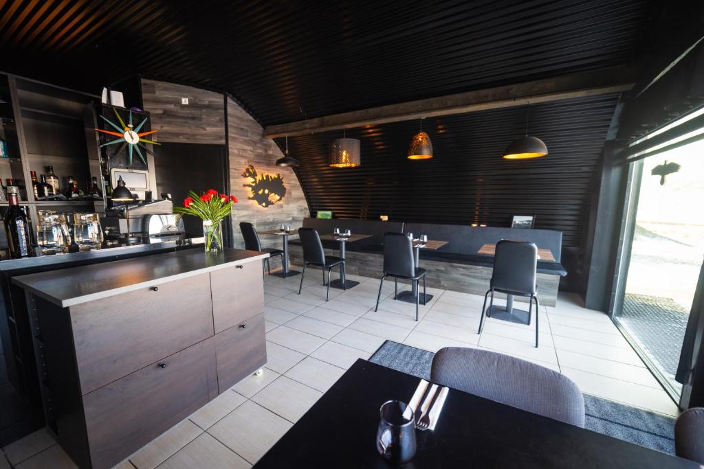 Hlíð í HörðudalDalahyttur的餐厅设有酒吧,配有桌椅