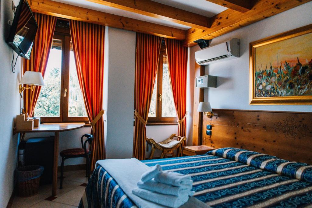 阿科Arciduca Charming House Room & Breakfast的卧室配有一张床、一张书桌和窗户。
