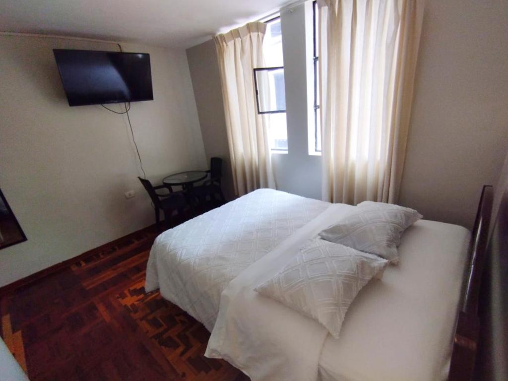 卡哈马卡Hotel la encantada的卧室配有白色的床和窗户。