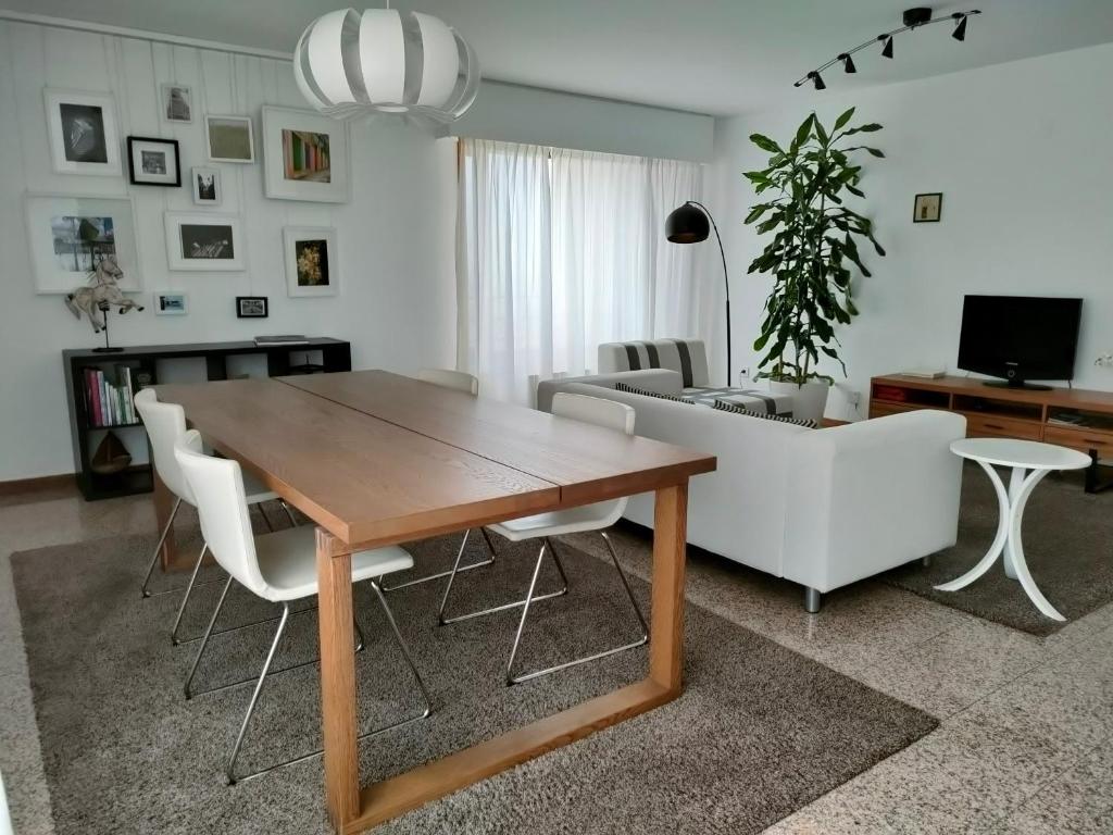 加亚新城Douro View Apartment的客厅配有木桌和白色椅子