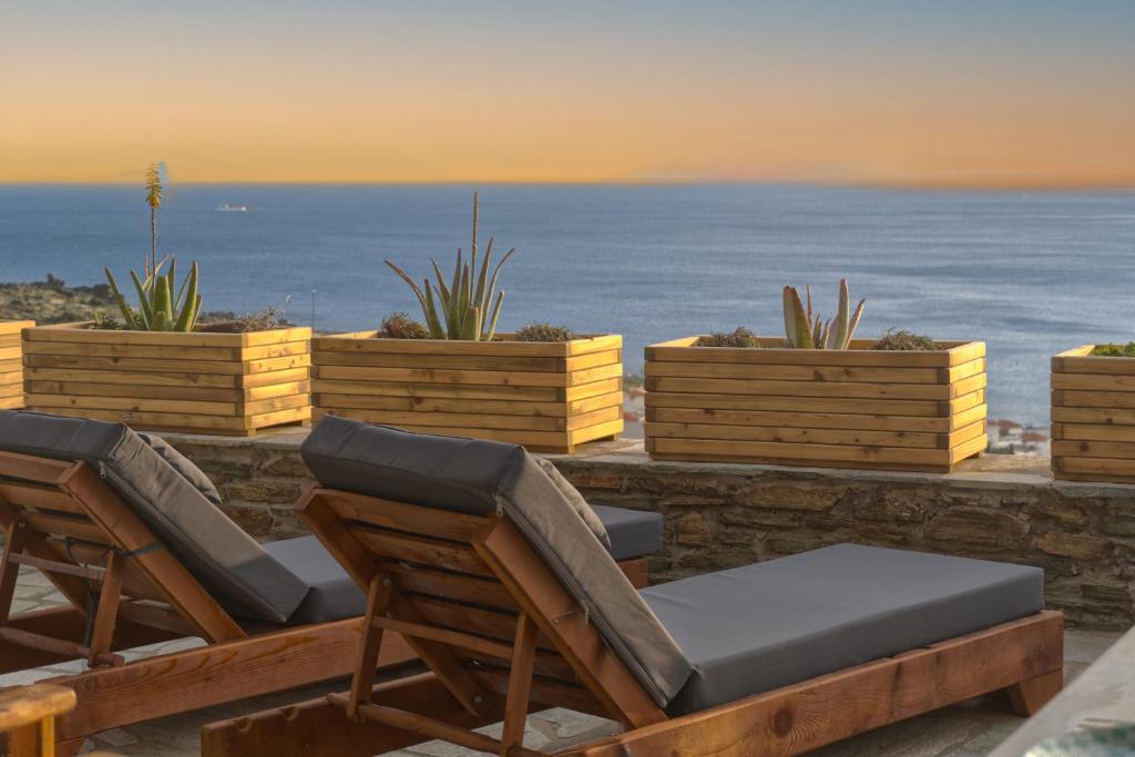 巴特斯欧"Aloe On the Rock", 3-BDR Villa next to Batsi Bay的一组椅子坐在一个与大海相连的山脊上
