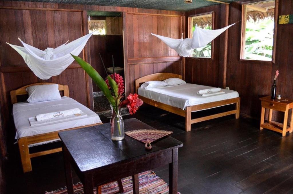 马尔多纳多港River Point Hostel的一间卧室配有两张床和一张鲜花桌
