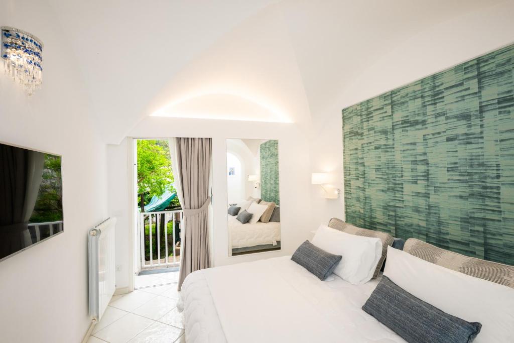 普莱伊亚诺La Divina Amalfi Coast的一间带白色床的卧室和一个阳台