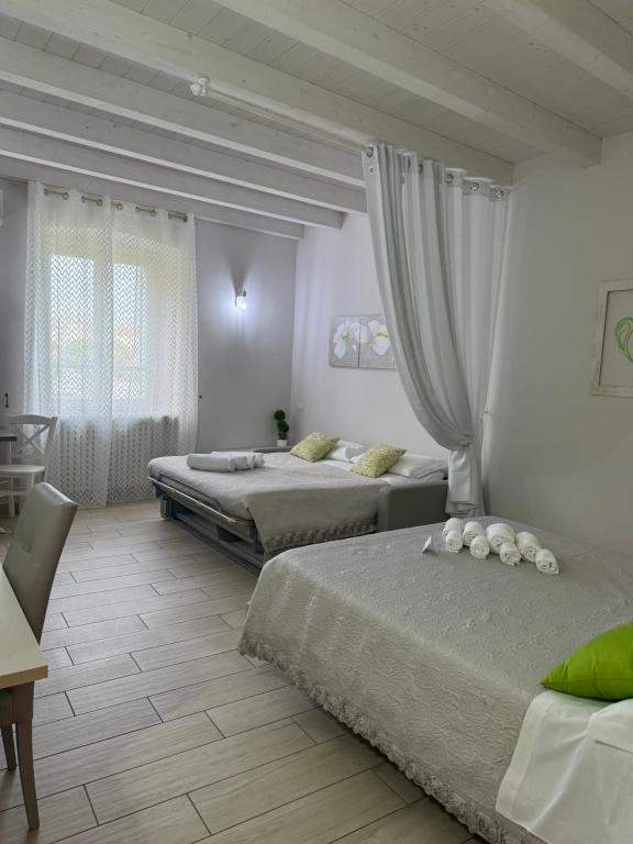 波佐伦戈B&B La Terrazza的一间卧室配有两张床和一张桌子及椅子