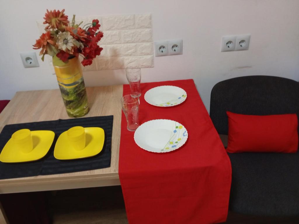 利沃夫Апартамент в Новобудові Стрийська Автовокзал的一张桌子,上面有两个盘子和红色桌布