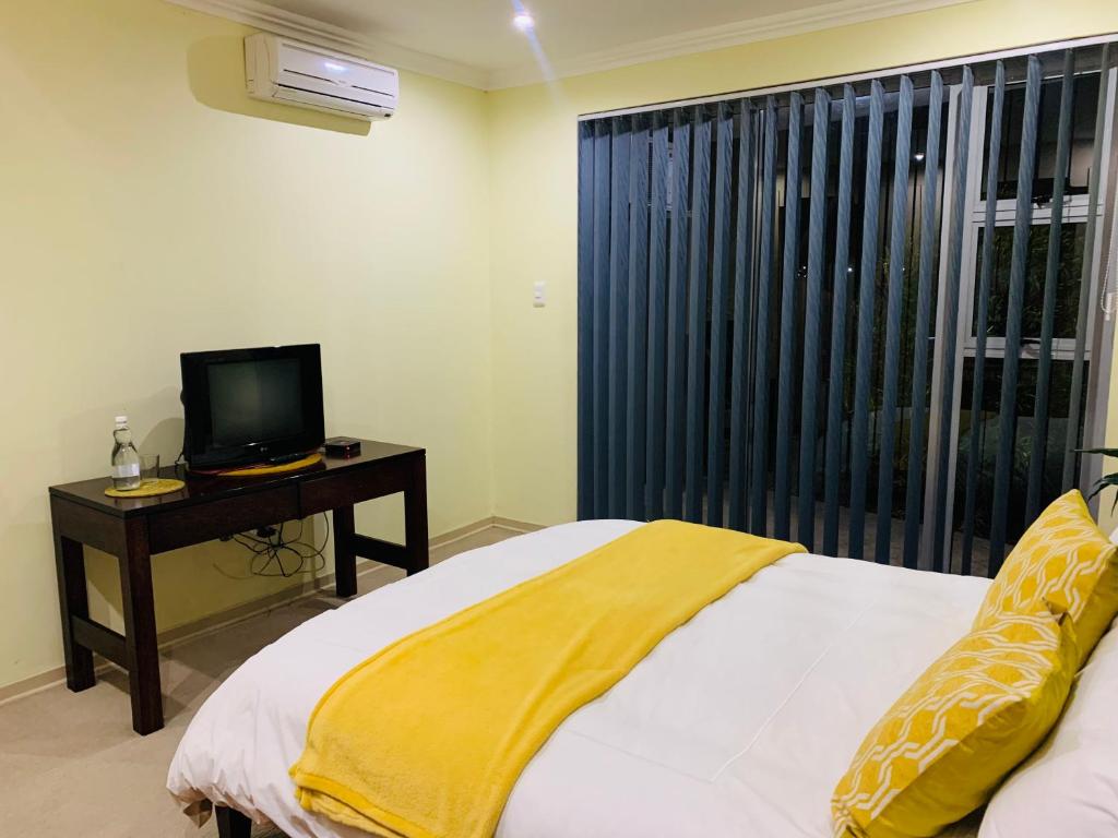 MatsaphaAtonement private room的一间卧室设有一张床、一台电视和一个窗口。