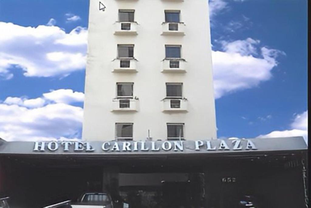圣保罗卡里隆广场酒店的白色的酒店建筑,上面有标志