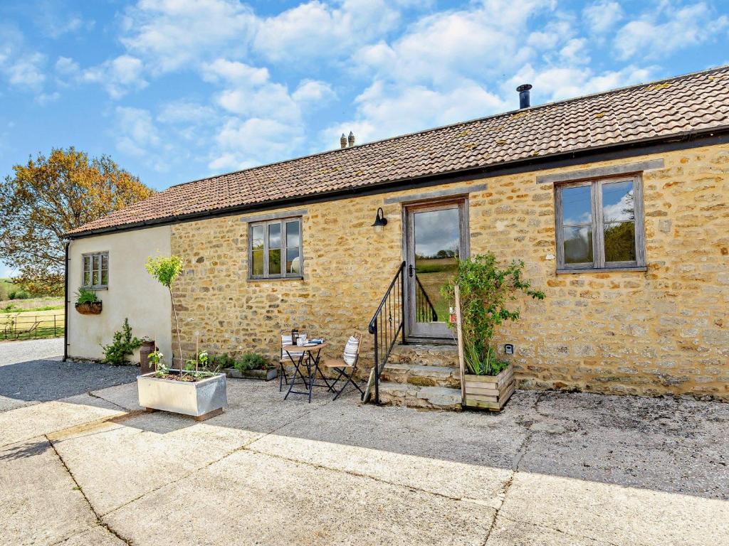 Mosterton1 bed in Beaminster 75193的砖屋前设有桌椅