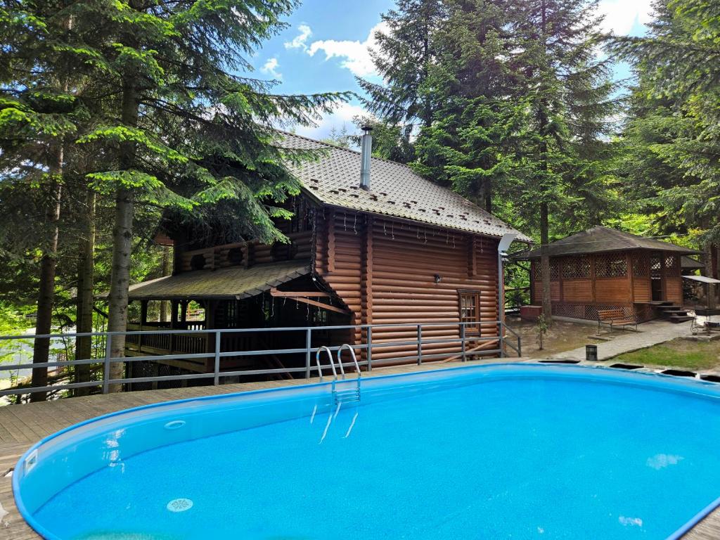 米戈韦Gostynniy Dvir Коттеджи的小木屋前方设有游泳池