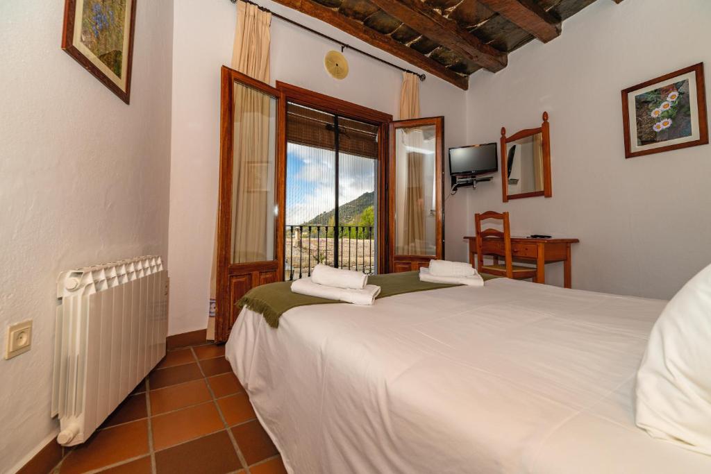 特雷韦莱斯拉弗拉瓜一号酒店的一间卧室设有两张床和窗户。