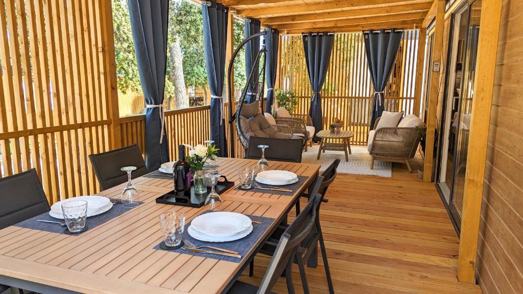 比奥格勒·纳·莫鲁Mobile Homes Jaki - Camp park Soline的甲板上一张带椅子和盘子的木桌
