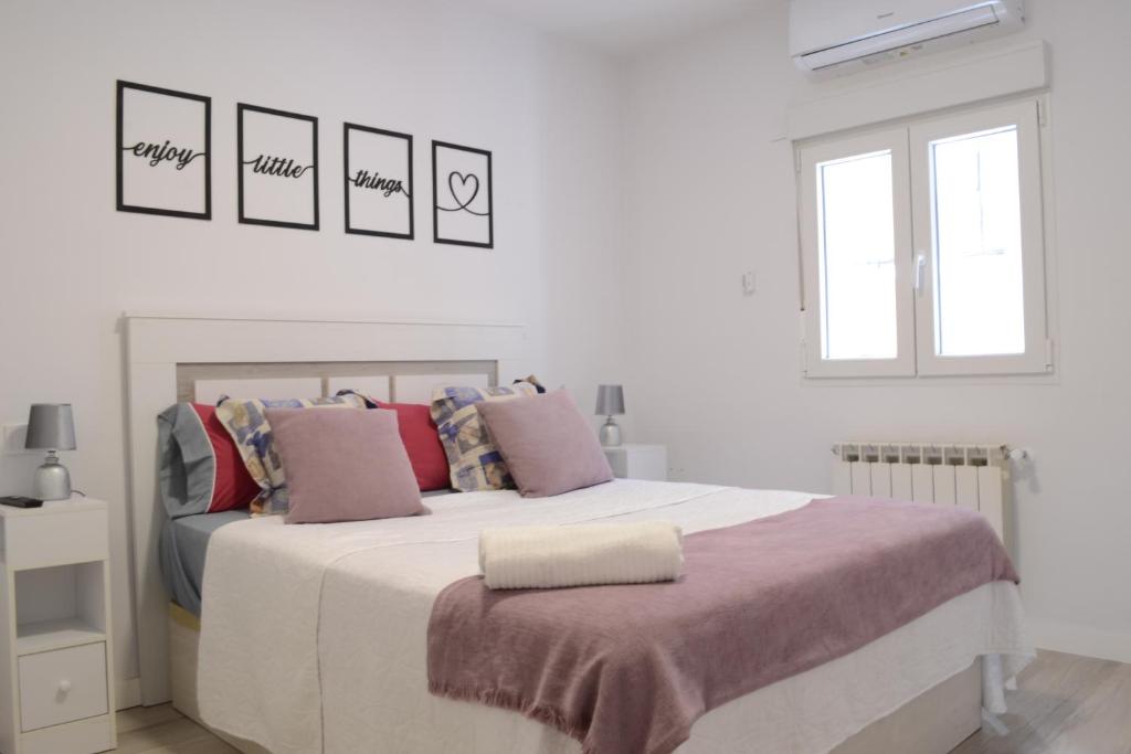 马德里Bonito Apartamento Madrid Rio的白色卧室配有带粉红色枕头的大床