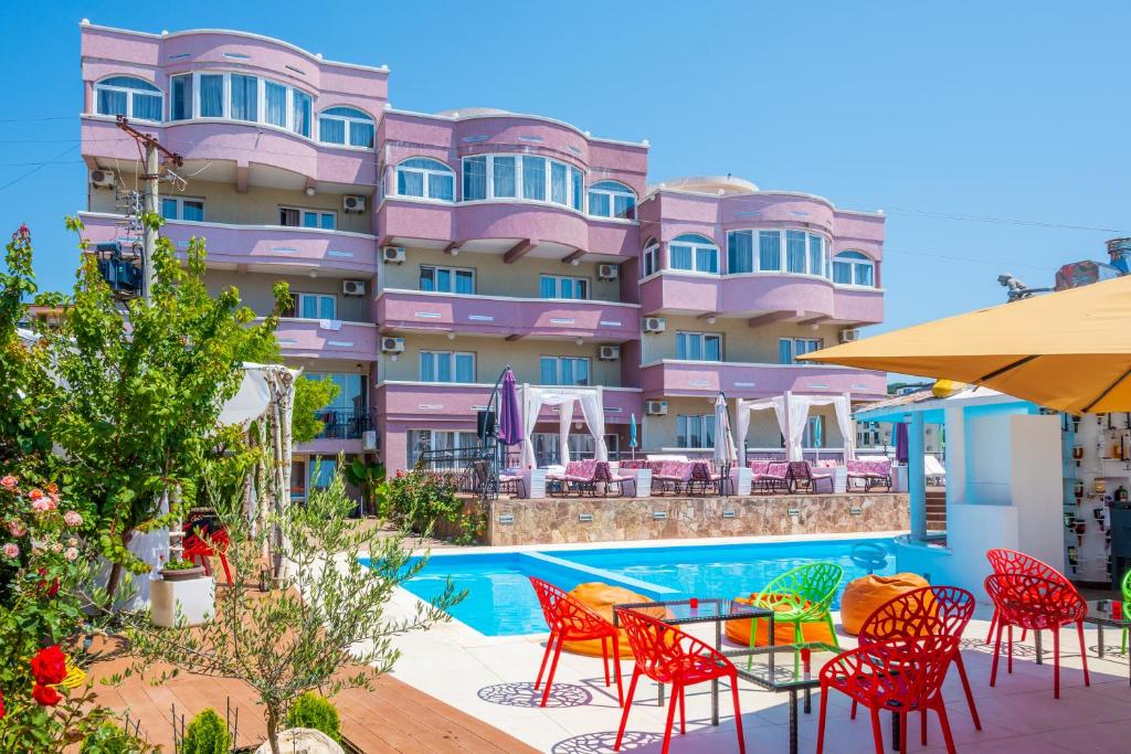 多布拉沃达皇家海岸住宿酒店的酒店设有一个游泳池和桌椅