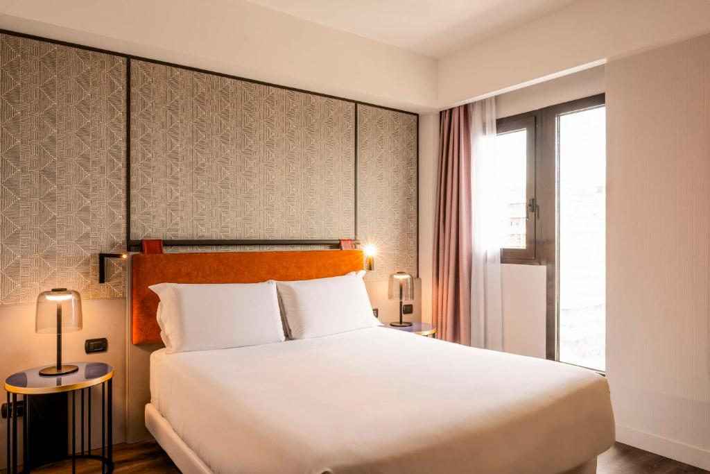 卡塔尼亚卡塔尼亚中心NH酒店的卧室设有一张白色大床和一扇窗户。